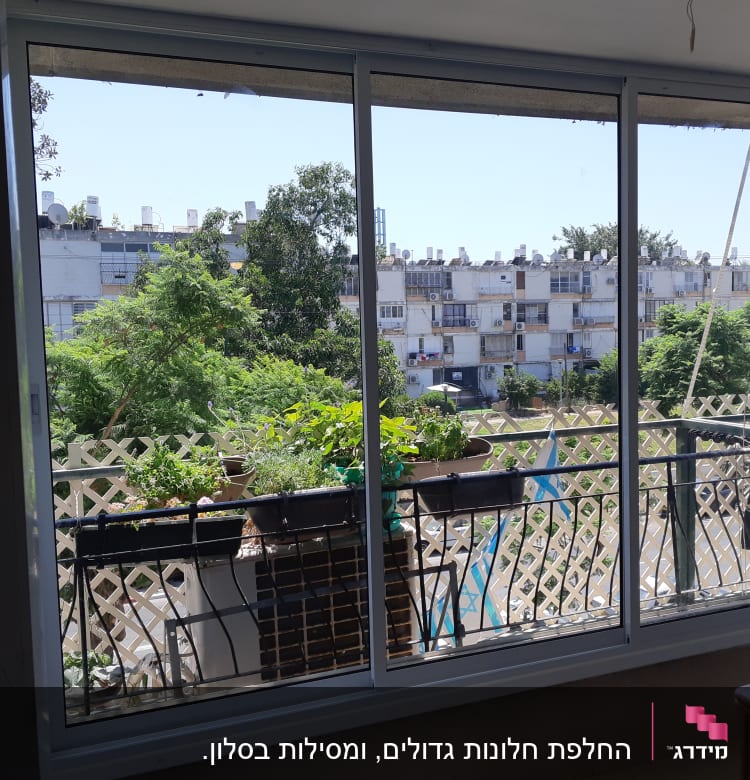 חלון אלומיניום עם מסגרת כסופה ומעקה חיצוני